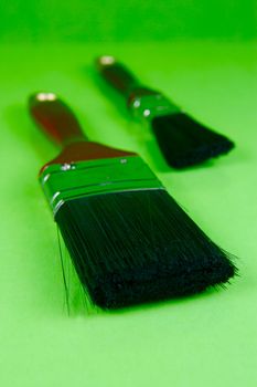 Paint brushes isolated against a green background
