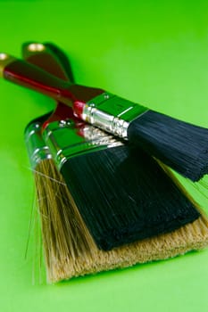 Paint brushes isolated against a green background