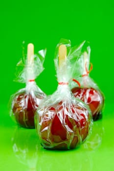 Candy apples isolated against a green background