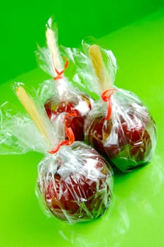 Candy apples isolated against a green background