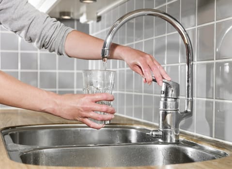 Human filling a glass of water