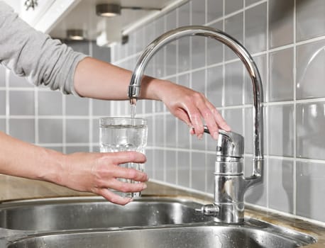 Human filling a glass of water