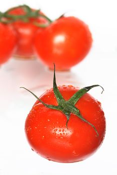 Fresh tomatoes with water drops on white background