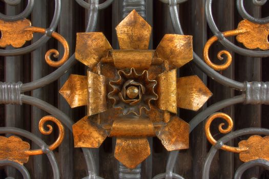 Bronze flower and ornaments on iron gate reminiscient of ancient times