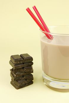 A glass of chocolate milk isolated against a yellow background