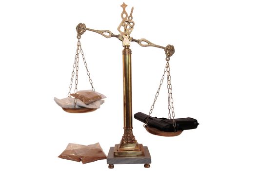 an antique scales against a white background with drugs and gun depicting drug crime
