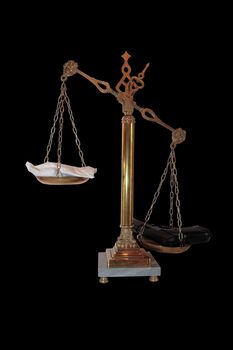 an antique scales against a black background with drugs and gun depicting drug crime with clipping path