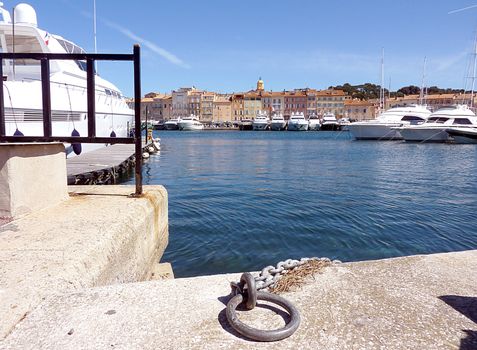Yachts at Saint-Tropez's harbor with its buildings and bell tower by beautiful weather, France