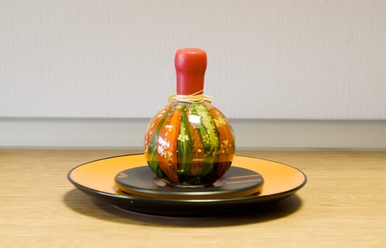 Decorative bottle on the ceramic plate on the table