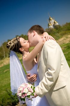 kiss of bride and groom outdoors