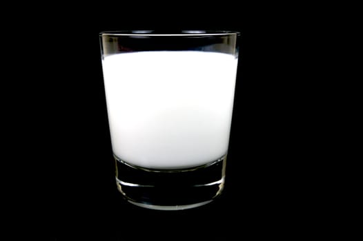 A glass of milk isolated against a black background