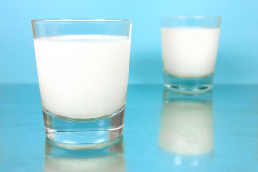 A glass of milk isolated against a blue background