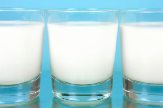 A glass of milk isolated against a blue background