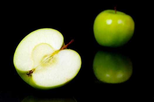 Red and green apples isolated against a black background