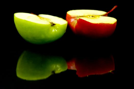 Red and green apples isolated against a black background