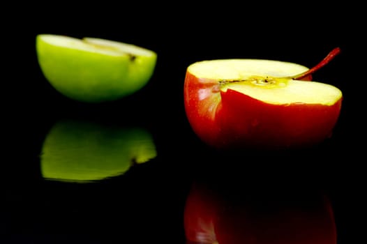 Red and green apples isolated against a black background