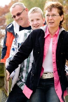 Happy young family on the bridge on the playground