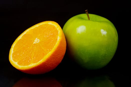 Apples and oranges isolated against a black background