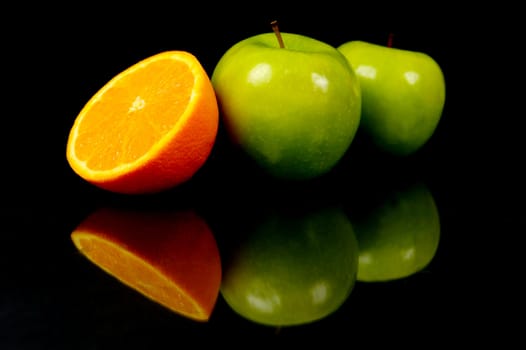 Apples and oranges isolated against a black background