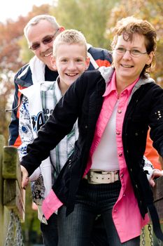 Happy young family on the bridge on the playground