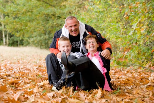 Happy young family in the autumn forest