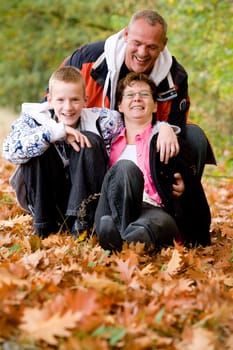 Happy young family in the autumn forest