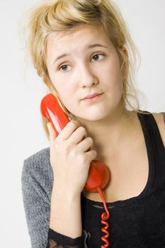 sad young girl and vintage red telephone