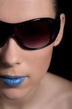 Beautiful closeup portrait of a woman with sunglasses and blue lipstick