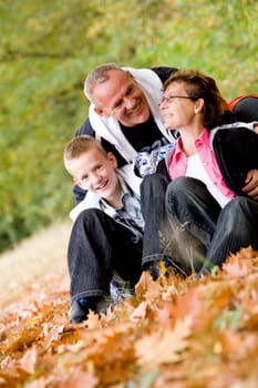 Happy young family in the autumn forest