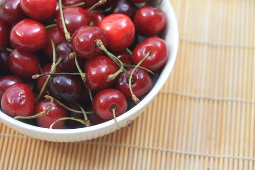 A group of juicy, fresh cherries in a white bowl
