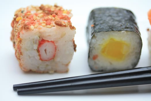 Two pieces of sushi� sesame and rice and a traditional Makisushi, made from rice rolled in seaweed called Nori