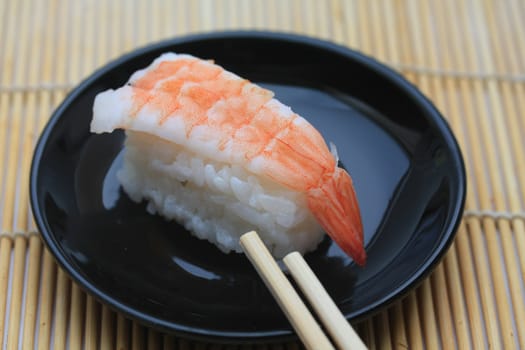 A piece of nigirisushi, rice with a scrimp topping