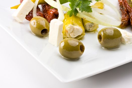 white plate with antipasti - olives, tomatos and peperoni