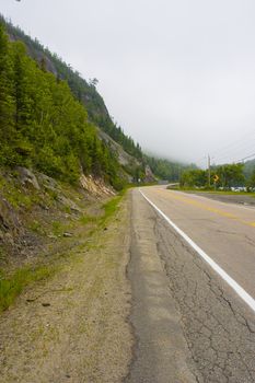 a foggy road going up to the mountains