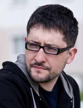 Portrait of a young male caucasian student with beard and glasses