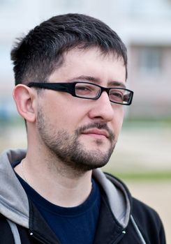 Portrait of a young male caucasian student with beard and glasses