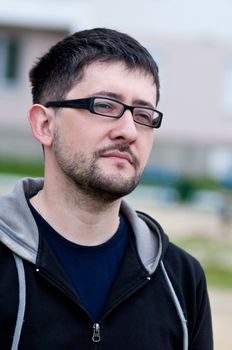 Portrait of a young male caucasian student with beard and glasses