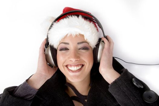 happy female listening music and wearing christmas hat against white background