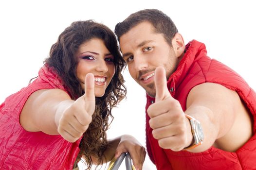 cheerful young couple showing thumbs up on an isolated white background