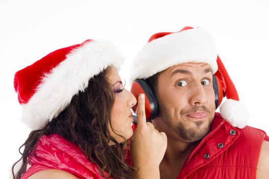 loving american couple wearing christmas hat and woman shushing on an isolated background