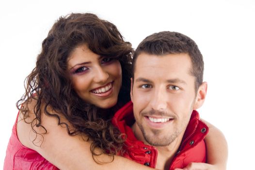 cheerful young couple carrying piggyback against white background