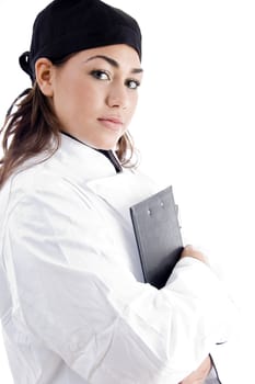 beautiful female chef holding notepad against white background