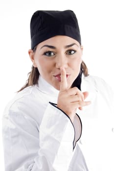 young beautiful chef shushing with finger on an isolated white background