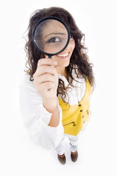 young girl holding magnifier and showing her magnified eye on an isolated white background