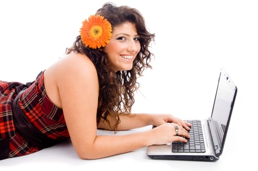 young laying model working on laptop on an isolated white background