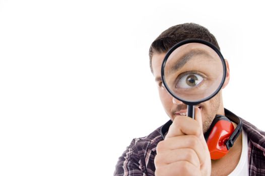 man looking through magnifying glass against white background