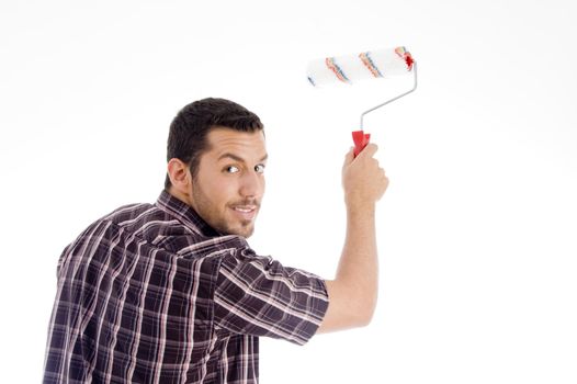 male looking backward while using roller brush with white background