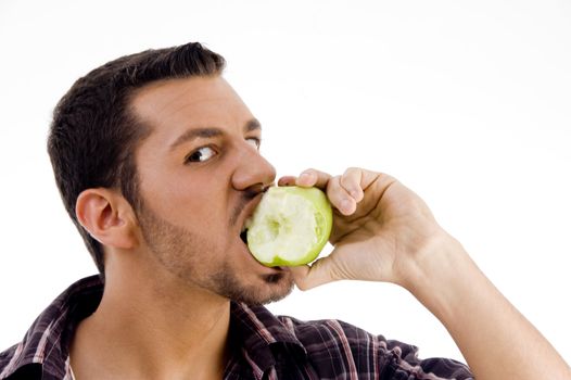 man looking at camera while eating apple with white background