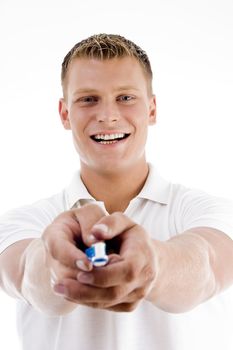 smiling male showing tooth brush against white background