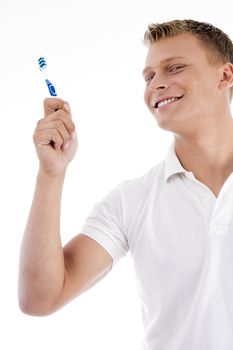 smiling male holding tooth brush against white background